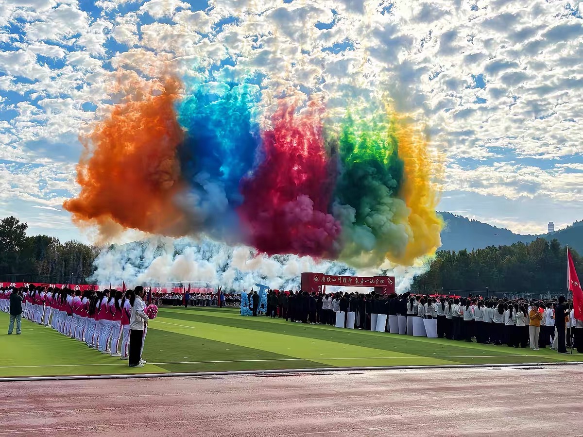 开幕式上橙蓝红绿黄彩烟在运动场上空绽放